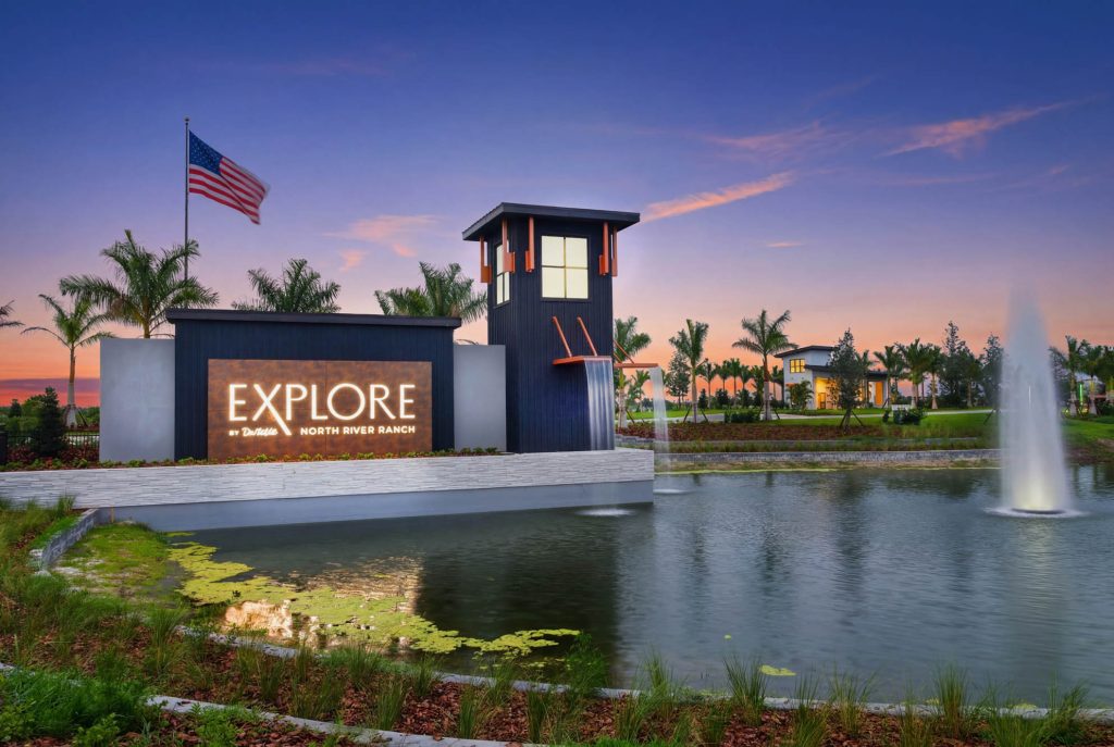 Explore by Del Webb entrance and illuminated fountain at sunset
